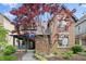 Charming brick home with a covered front porch and lush landscaping at 1537 Carrollton Ave, Indianapolis, IN 46202