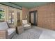Cozy front porch featuring comfortable wicker seating, a stylish rug, and brick detailing for a charming outdoor space at 1537 Carrollton Ave, Indianapolis, IN 46202