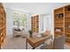 Bright home office with custom built-in shelving, hardwood floors, and a large window offering plenty of natural light at 1537 Carrollton Ave, Indianapolis, IN 46202