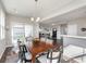 Dining area with a wooden table, stylish chairs, and an open layout to a living space and sliding glass door at 1695 Jackson St, Fortville, IN 46040