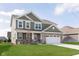 Charming two-story home with a brick facade, a three car garage, and a well-manicured lawn at 1695 Jackson St, Fortville, IN 46040