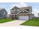 Charming two-story home with a brick facade, a three car garage, and a well-manicured lawn at 1695 Jackson St, Fortville, IN 46040