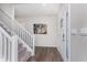 Bright foyer featuring hardwood floors, a staircase with white railings and a glass-paneled front door at 1695 Jackson St, Fortville, IN 46040