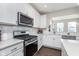 Well-equipped kitchen with stainless steel appliances, white cabinetry, and ample counter space at 1695 Jackson St, Fortville, IN 46040