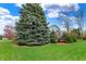 Green grassy yard and mature trees surrounding a two-story home with blue siding at 1716 Teakwood Ct, Lafayette, IN 47905