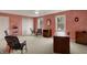 Open living room area with unique pink-toned walls, carpet flooring, and large windows at 1716 Teakwood Ct, Lafayette, IN 47905