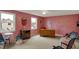 Bright living room features pink walls, neutral carpet, ceiling fan, and furniture seating at 1716 Teakwood Ct, Lafayette, IN 47905