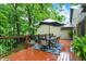 Outdoor living on a spacious deck with patio table, chairs and umbrella with tree backdrop at 2143 Sunderland Dr, Martinsville, IN 46151