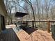 Wooden deck with outdoor dining set, umbrella, and views of the wooded backyard at 2143 Sunderland Dr, Martinsville, IN 46151