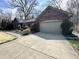 Brick home with a concrete driveway and attached garage, complemented by well-maintained landscaping at 2143 Sunderland Dr, Martinsville, IN 46151