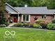 Well-maintained brick home featuring a manicured front yard, garden, and a red front door at 2143 Sunderland Dr, Martinsville, IN 46151