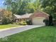 Charming brick home featuring a well-manicured lawn and colorful landscaping with a two car garage at 2143 Sunderland Dr, Martinsville, IN 46151
