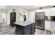 A modern kitchen island offers additional counter space and seating next to stainless steel refrigerator at 2143 Sunderland Dr, Martinsville, IN 46151