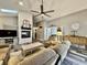 Bright living room with a fireplace, modern ceiling fan, and open layout with luxury vinyl plank flooring at 2143 Sunderland Dr, Martinsville, IN 46151