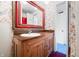 Charming bathroom showcasing a wooden vanity with sink, red mirror, and bicycle-themed wallpaper at 2309 Pearl St, Columbus, IN 47201