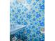 A powder blue bathroom featuring a wall to wall floral wallpaper, toilet and corner sink at 2309 Pearl St, Columbus, IN 47201