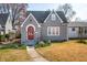 Charming gray two-story home featuring a red front door, well-kept lawn, and blooming spring flowers at 2309 Pearl St, Columbus, IN 47201