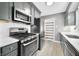 This kitchen boasts stainless steel appliances, gray cabinetry, and bright white subway tile backsplash at 2309 Pearl St, Columbus, IN 47201