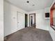 The bedroom has neutral carpeting, access to a closet and adjacent room, and painted block walls at 2429 N Arsenal Ave, Indianapolis, IN 46218