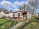 Quaint single-Gathering home with a stone foundation and red trim around the windows and door at 2429 N Arsenal Ave, Indianapolis, IN 46218