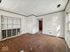 Living room featuring brown carpet, unfinished shelving, and bright light from the side window at 2429 N Arsenal Ave, Indianapolis, IN 46218