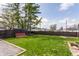 Expansive backyard featuring lush green grass, a wooden fence, and a red storage shed at 310 W Staat St, Fortville, IN 46040