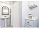 Clean and bright bathroom with pedestal sink, decorative cabinet, and shower with curtain at 310 W Staat St, Fortville, IN 46040