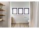 Bright bathroom with wood shelves, three windows, warm-toned wooden floors, and an open shower at 310 W Staat St, Fortville, IN 46040