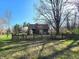 View of the rear of the house and backyard showcasing a wooden fence and established trees at 3395 State Road 44, Martinsville, IN 46151
