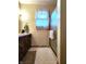 Neutral toned bathroom with window, shower, cabinet, and neutral-toned hexagon tile at 3395 State Road 44, Martinsville, IN 46151