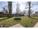 Backyard with a trampoline surrounded by grass and bare trees and fenced perimeter at 3636 N Chester Ave, Indianapolis, IN 46218