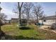 Large, open backyard with a trampoline and patio seating area, great for outdoor activities at 3636 N Chester Ave, Indianapolis, IN 46218