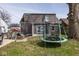 This backyard features a trampoline, gray vinyl siding, grass, and plenty of room to play at 3636 N Chester Ave, Indianapolis, IN 46218