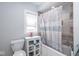 Clean bathroom featuring a bathtub with shower, tile, a cabinet for storage, and a window at 3636 N Chester Ave, Indianapolis, IN 46218