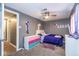 A bedroom features a closet, fan, carpeted floors, and colorful decor creating a whimsical personal space at 3636 N Chester Ave, Indianapolis, IN 46218
