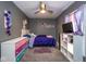 This bedroom has gray walls, ceiling fan, decor, plush carpet and is furnished with a bed, dresser and shelving unit at 3636 N Chester Ave, Indianapolis, IN 46218