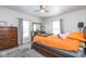 Comfortable bedroom featuring a ceiling fan, dresser, soft carpet, and natural light from large windows at 3636 N Chester Ave, Indianapolis, IN 46218