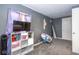 View of gray bedroom with purple accents, showing shelving unit and chair, and having overhead lighting at 3636 N Chester Ave, Indianapolis, IN 46218