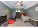 Gray bedroom with ceiling fan and dinosaur wall decorations, with two beds and gray storage units at 3636 N Chester Ave, Indianapolis, IN 46218
