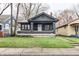 Charming bungalow home with a welcoming front porch and dark exterior paint at 3704 Graceland Ave, Indianapolis, IN 46208