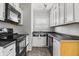 Cozy kitchen features white cabinets, dark countertops, and modern black appliances at 3704 Graceland Ave, Indianapolis, IN 46208