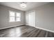 Empty bedroom with wood-look flooring, closet, and a large window at 3712 N Olney St, Indianapolis, IN 46218