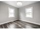Empty bedroom with wood-look flooring and two windows providing ample natural light at 3712 N Olney St, Indianapolis, IN 46218