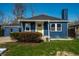 Inviting blue single-story home with a bright yellow front door and a well-kept yard at 3712 N Olney St, Indianapolis, IN 46218
