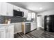 Modern kitchen with white cabinets, stainless steel appliances, and stylish tile backsplash at 3712 N Olney St, Indianapolis, IN 46218