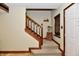 Inviting hallway with carpeted stairs, wood railing, and bright walls at 381 Stoneybrook Grove Dr, Greenwood, IN 46142