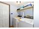 Compact laundry room with a washer, dryer, storage shelf, and a tiled floor at 381 Stoneybrook Grove Dr, Greenwood, IN 46142