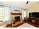 The living room has a stone fireplace, large windows, hardwood floors, and lots of natural light at 381 Stoneybrook Grove Dr, Greenwood, IN 46142