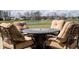 Patio furniture surrounds a fire pit in a backyard overlooking a serene pond and neighborhood at 3899 Chapel Hill Ct, Bargersville, IN 46106