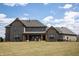 The backyard with tall green grass, a beautiful grey house, and blue skies at 3899 Chapel Hill Ct, Bargersville, IN 46106